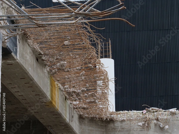 Obraz Demolition work on a construction site with concrete pillars, steel beams, etc.