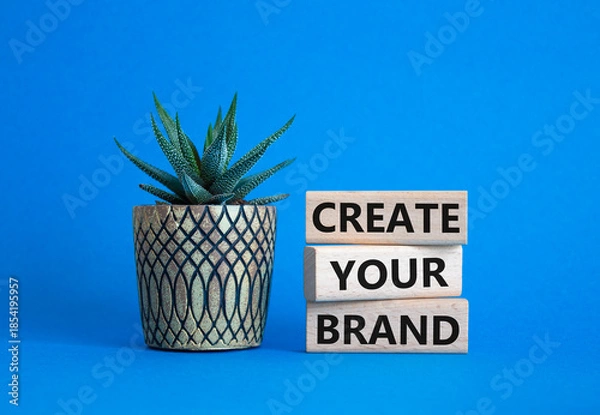 Obraz Brand symbol. Concept words Create your Brand on wooden blocks. Businessman hand. Beautiful blue background with succulent. Business and Create your Brand concept. Copy space.