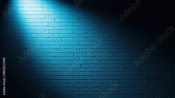 Fototapeta Blue spotlight illuminating a dark brick wall with dramatic lighting.