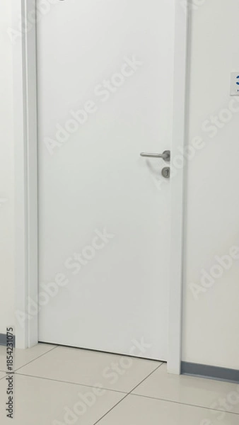 Fototapeta Minimalist white door of a consultation room in a modern clean medical center interior