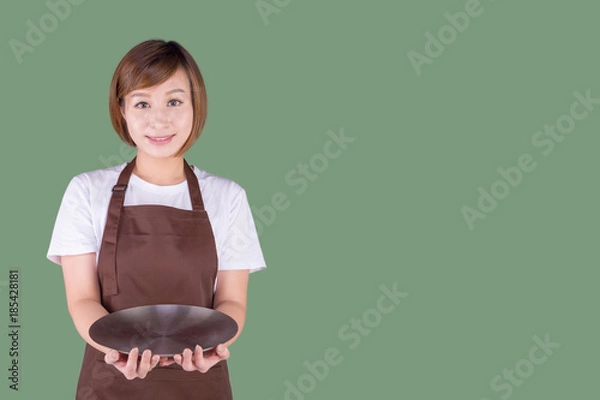 Obraz Waitress in apron holding a silver plate. Isolated on solid color background.  