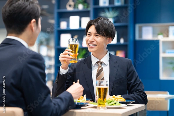 Obraz 飲食店でビールを飲む若いビジネスマン