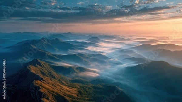 Obraz mountain ridge floating above thick fog, warm sunrise glow, epic cinematic view