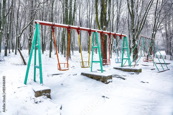 Fototapeta Empty swing in winter time with snow