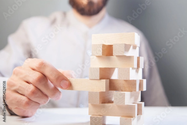Obraz businessman putting wooden blocks on wooden blocks as concept of strategy and business success.