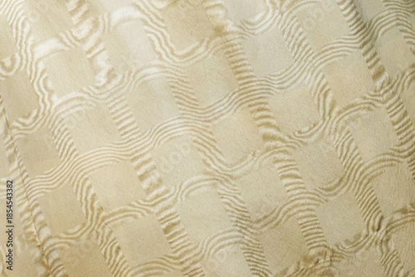 Fototapeta A soft beige fabric featuring a quilted, raised wave pattern