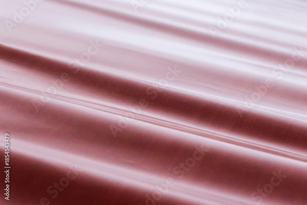 Fototapeta Red industrial fabric cascades in smooth waves, creating glossy background