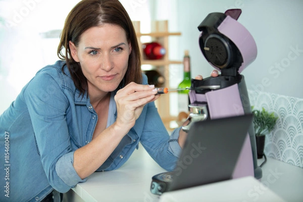 Obraz woman repairs a coffee machine