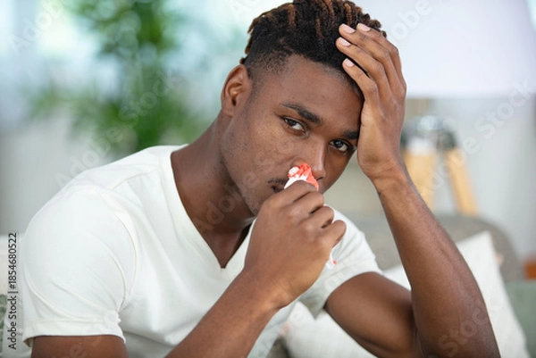 Obraz young man touching his bleeding nose