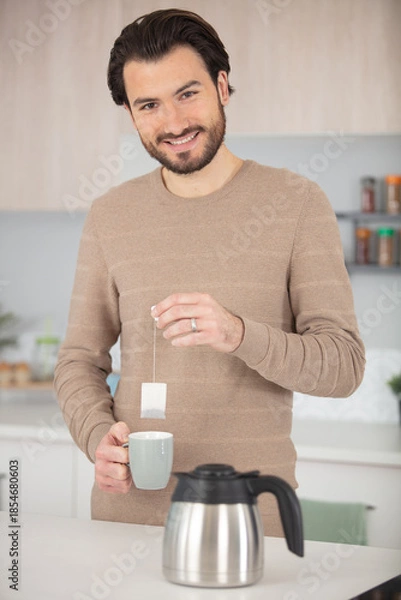 Obraz young man preparing tea in the kitchen