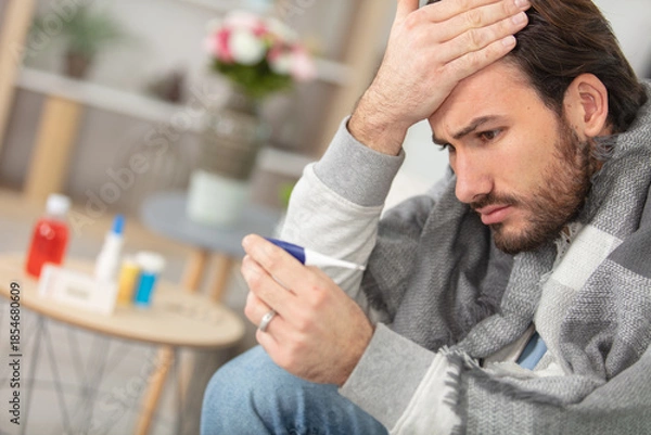 Obraz poorly man at home is worried about his high temperature