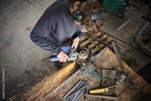 Obraz young farmer working with a grinder