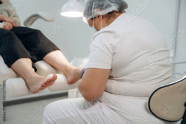 Obraz Podiatrist with client in clinic