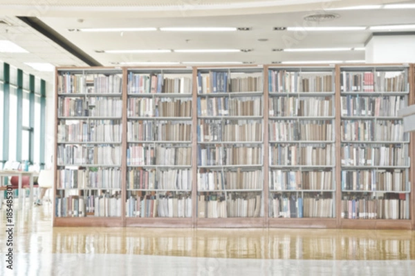 Fototapeta Abstract blurred bookshelf in library room.