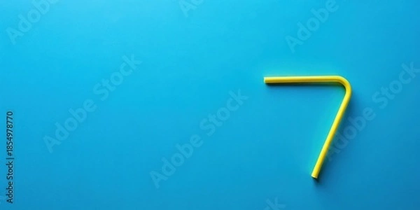 Obraz A vibrant yellow drinking straw forms the number seven against a solid azure background.