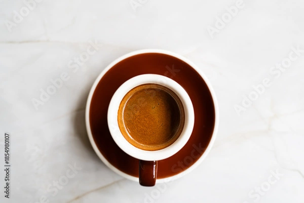 Obraz Coffee in a brown cup, flat lay on marble surface table