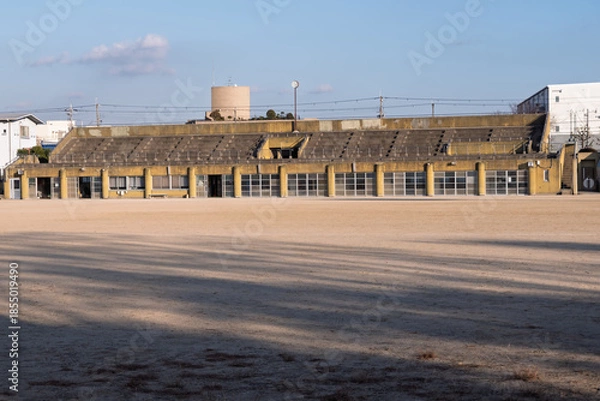 Obraz 松原市民運動広場のコンクリート製メインスタンドと冬の長い影