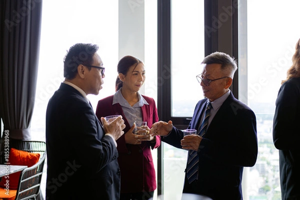 Obraz Group of business professionals talking and networking during corporate event in high-rise office, representing professional communication, leadership, and workplace connection