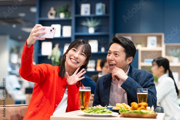 Fototapeta 飲食店で写真を撮るミドルのカップル