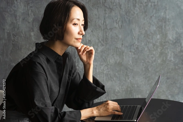 Fototapeta テーブルでラップトップを操作する女性　ライフスタイルイメージ