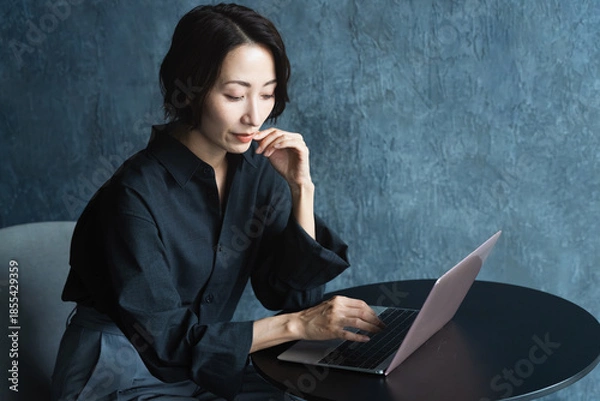 Fototapeta テーブルでラップトップを操作する女性　ライフスタイルイメージ