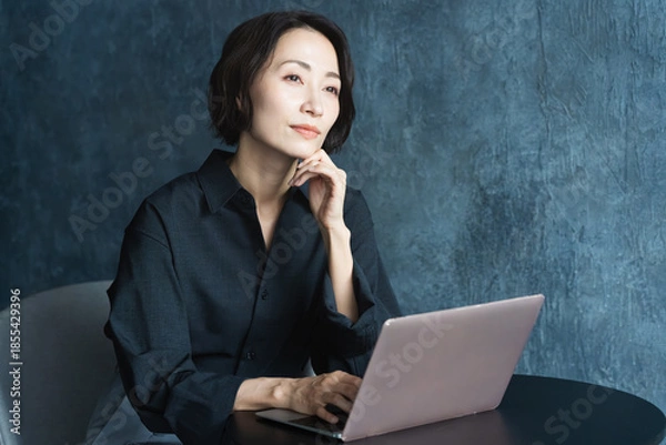 Fototapeta テーブルでラップトップを操作する女性　ライフスタイルイメージ