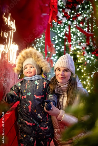 Obraz A cheerful mother and son playing outside on New Year’s Eve