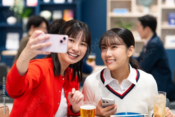 Fototapeta 女子会で写真を撮る若い女性