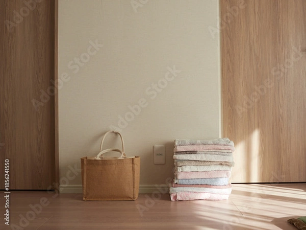 Obraz 家のリビングの床にある編み鞄とバスタオルの様子