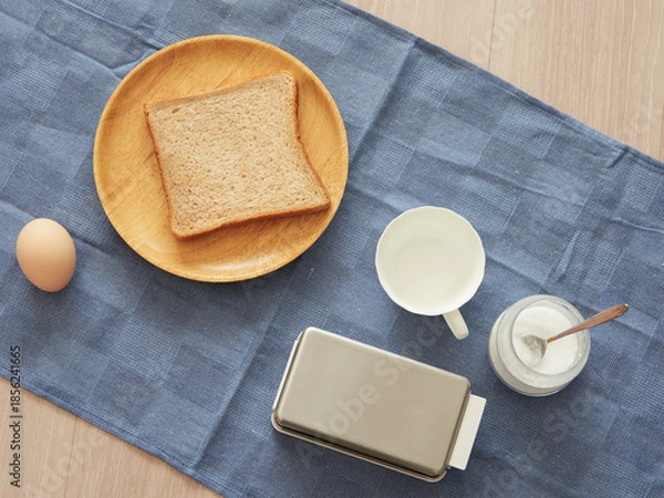 Obraz 家のリビングのテーブルの上にある食パンとコップの様子