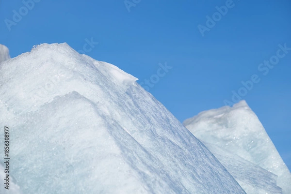 Obraz Ice pyramids on blue sky background.