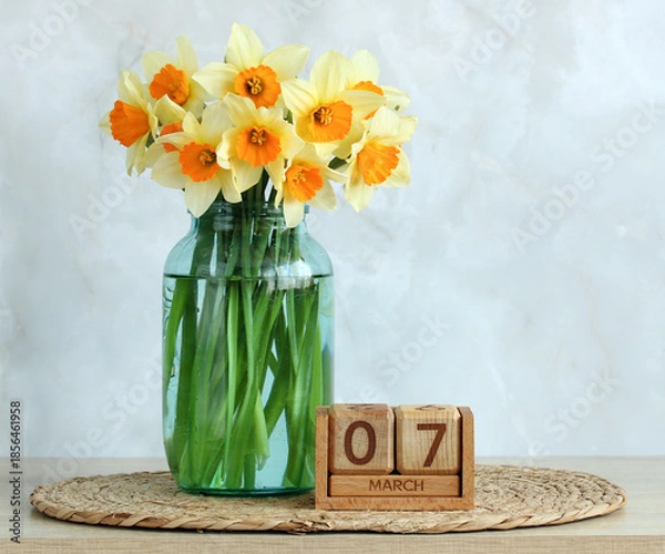 Fototapeta Daffodils in vase with march 7 wooden calendar