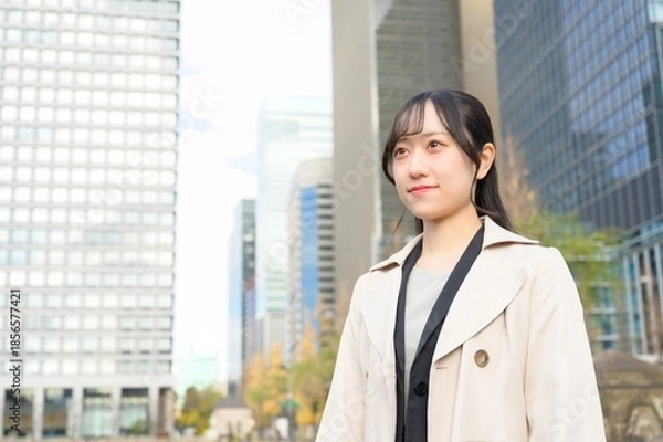 Fototapeta オフィス街で遠くを見つめる20代のビジネスウーマン