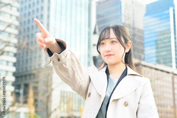 Fototapeta オフィス街で指差しをする日本人ビジネスウーマン