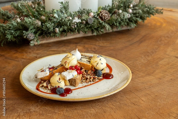 Obraz Elegant holiday dessert with cake, berries, and cream on rustic table
