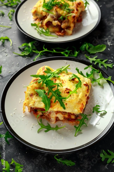 Fototapeta Homemade lasagna with minced beef bolognese and bechamel sauce topped wild arugula, parmesan cheese