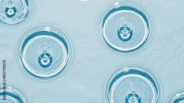 Fototapeta Water droplets creating ripples on calm blue surface