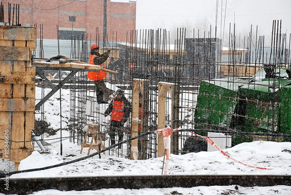 Fototapeta Construction object.The construction of housing. Builders work in the winter, and cold, and snow