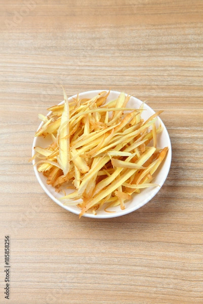 Obraz sliced fingerroot in the white small bowl on the wooden table