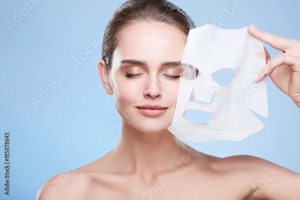 Fototapeta Woman removing mask from face