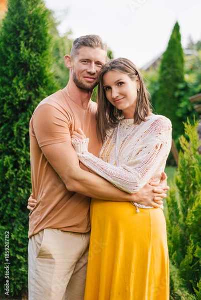 Obraz Smiling Couple Expecting Child Hug In Garden