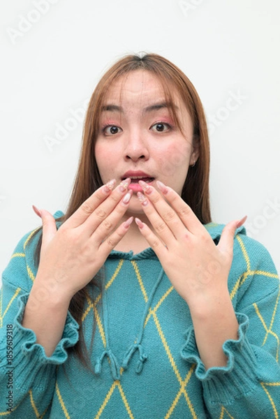 Fototapeta Portrait of a young surprised Asian woman against white background