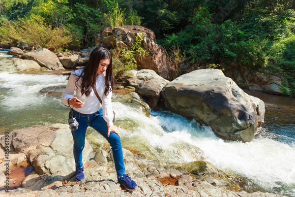 Fototapeta Woman hiking around mountains near the river at spring time.