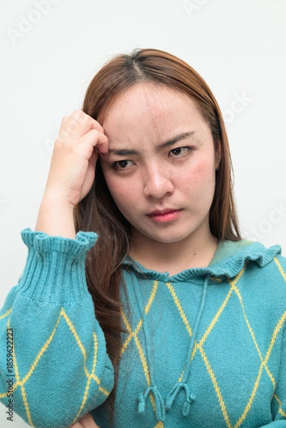 Fototapeta Portrait of a young stressed Asian woman against white background thinking
