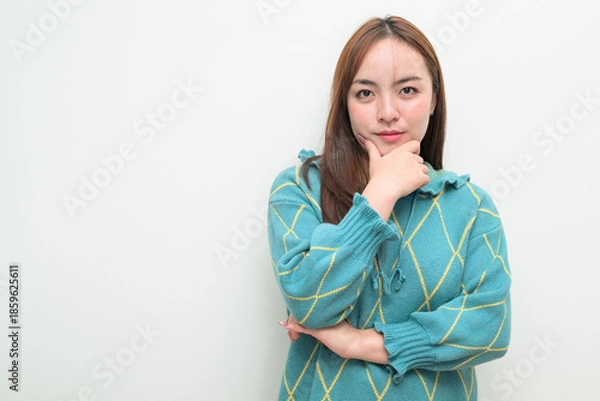 Fototapeta Portrait of a young Asian woman against white background thinking