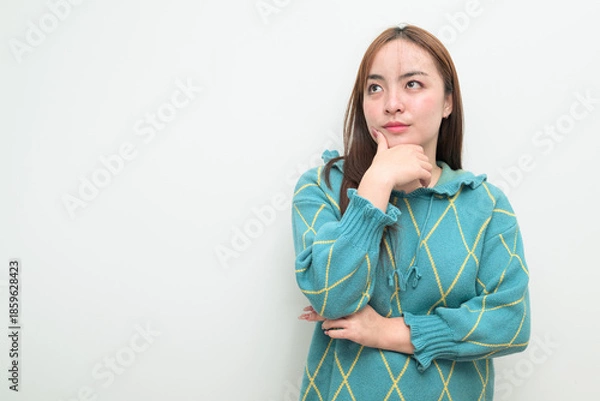 Fototapeta Portrait of a young Asian woman against white background thinking