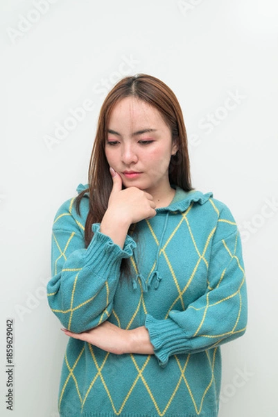 Fototapeta Portrait of a young Asian woman against white background thinking