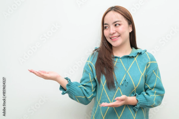 Fototapeta Portrait of a young happy Asian woman against white background showing copy space