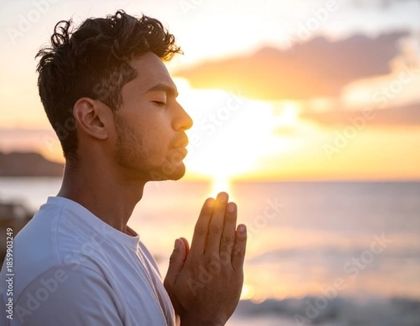 Obraz young man praying at sunset