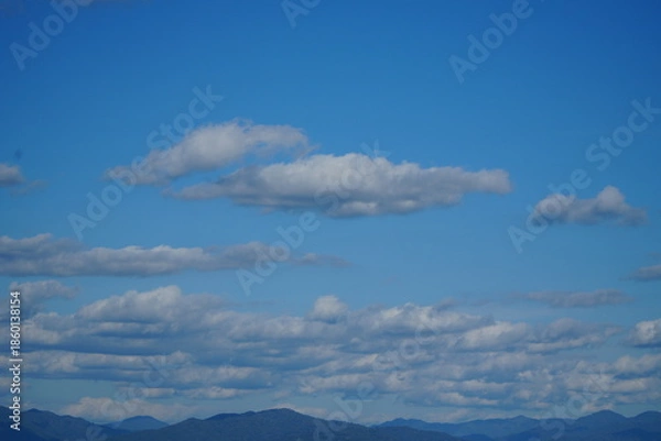 Obraz Mountain Range Under Clear Blue Sky with Soft Clouds